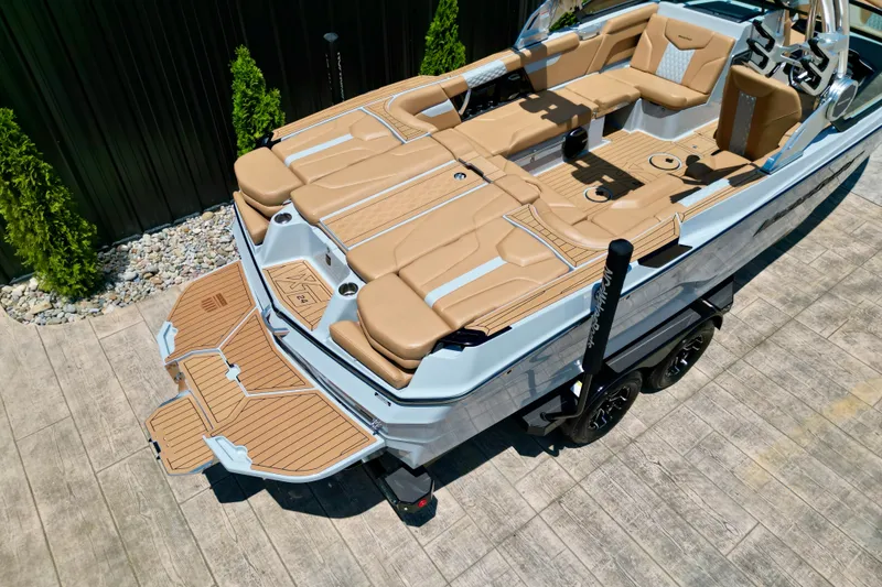 Slide: The Image of 2026 MasterCraft XT24 boat with tan interior and sleek design on a trailer. - 21