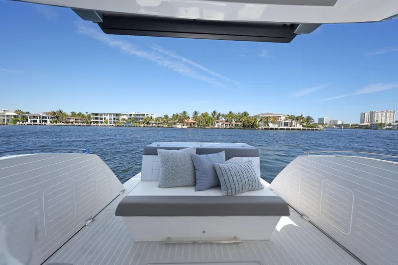 Slide: The Image of 2025 Valiatt 380 Bowrider boat interior with cushions, overlooking waterfront homes and clear blue sky. - 13