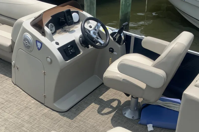 Slide: The Image of 2023 Cypress Cay Seabreeze 232 boat helm with steering wheel and captain's chair. - 5