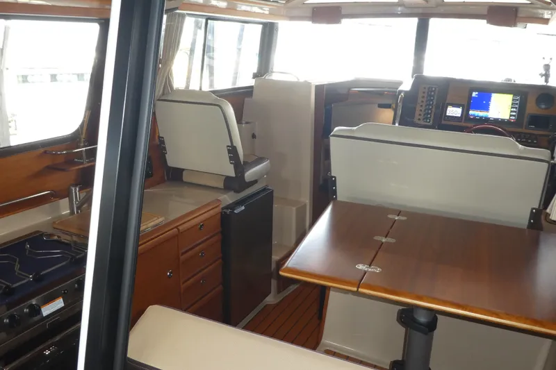 Slide: The Image of Interior of 2019 Ranger Tugs R-27 boat with dining area and navigation equipment. - 30