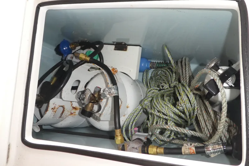 Slide: The Image of Storage compartment of 2019 Ranger Tugs R-27 with propane tank and ropes. - 53