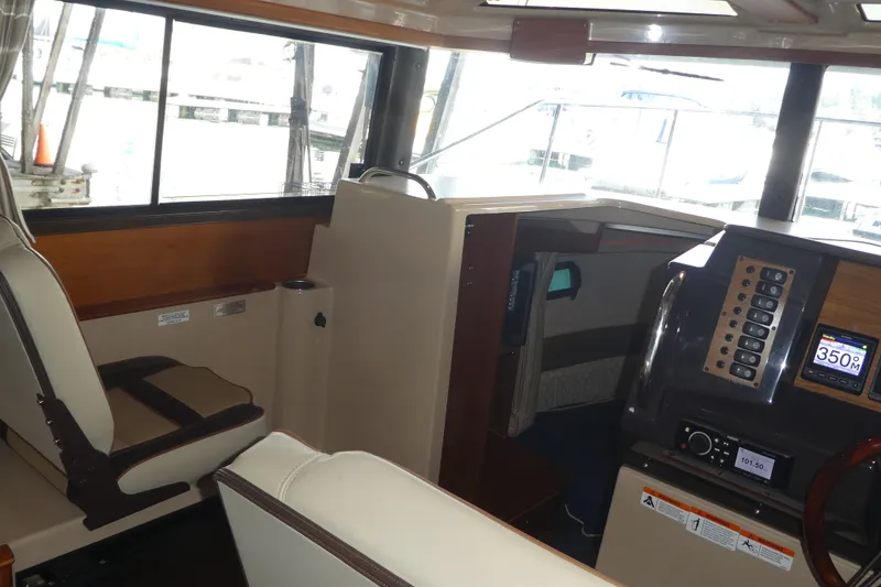 Slide: The Image of 2019 Ranger Tugs R-27 interior with helm, seating, and navigation controls. - 23