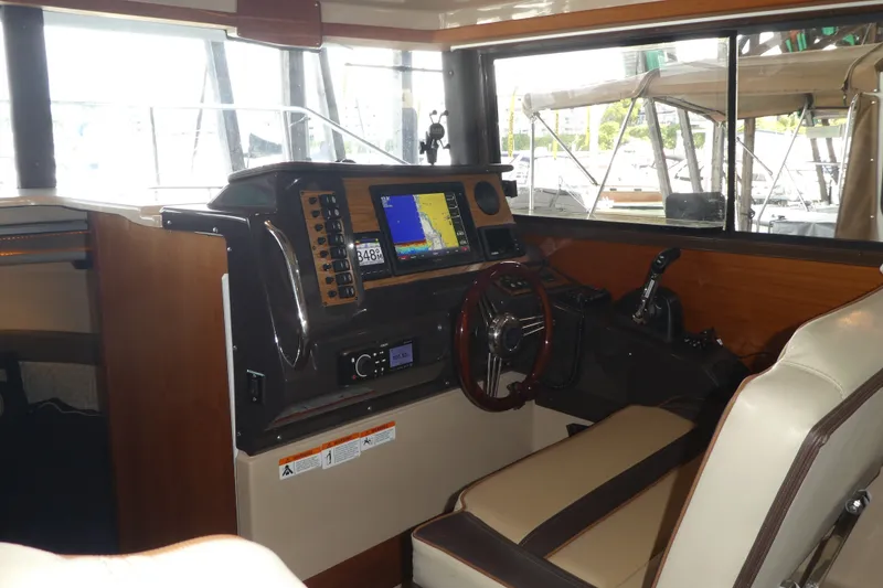 Slide: The Image of Interior helm of 2019 Ranger Tugs R-27 with navigation equipment and steering wheel. - 24