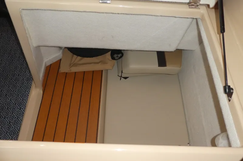 Slide: The Image of 2019 Ranger Tugs R-27 interior storage compartment with wooden flooring and cushions. - 47