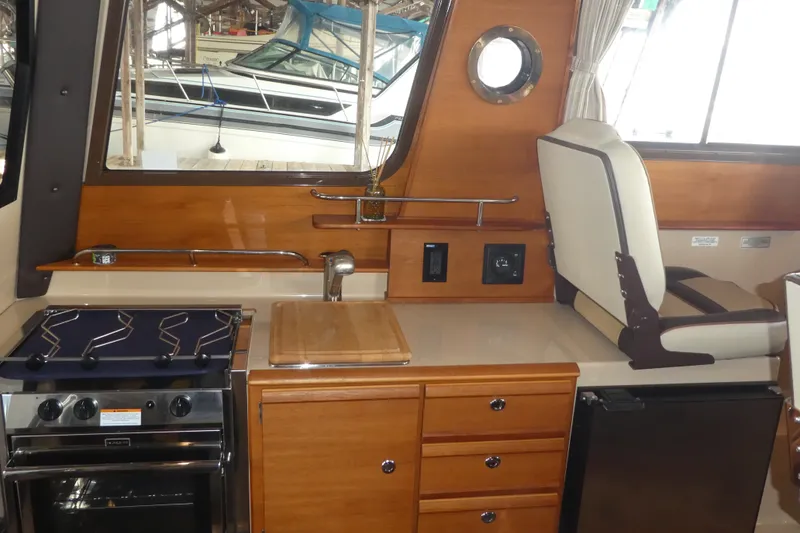 Slide: The Image of Interior of 2019 Ranger Tugs R-27 boat with kitchen and seating area. - 32