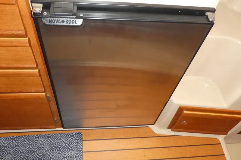 Slide: The Image of Nova Kool refrigerator in 2019 Ranger Tugs R-27 boat interior, featuring wood cabinetry and flooring. - 33