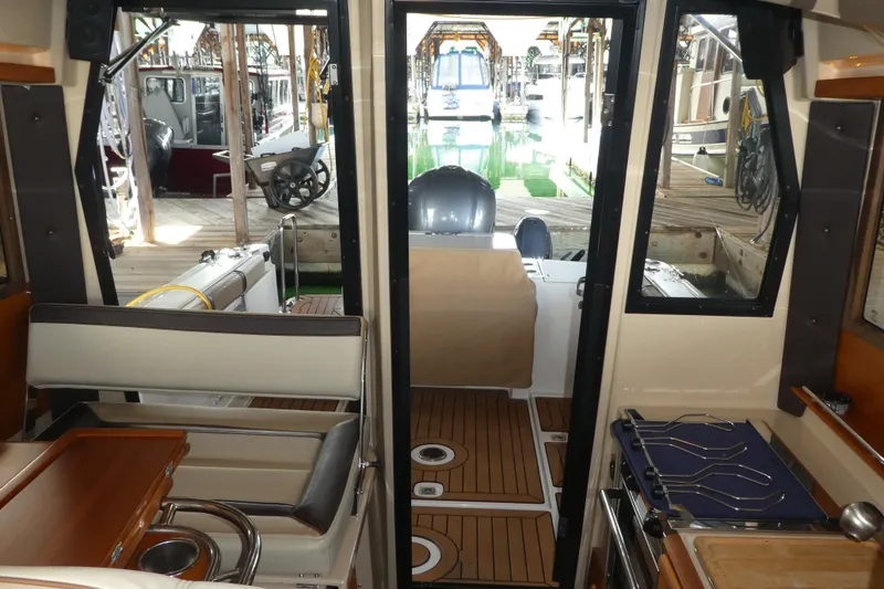 Slide: The Image of Interior view of 2019 Ranger Tugs R-27 boat with seating and docked marina. - 56