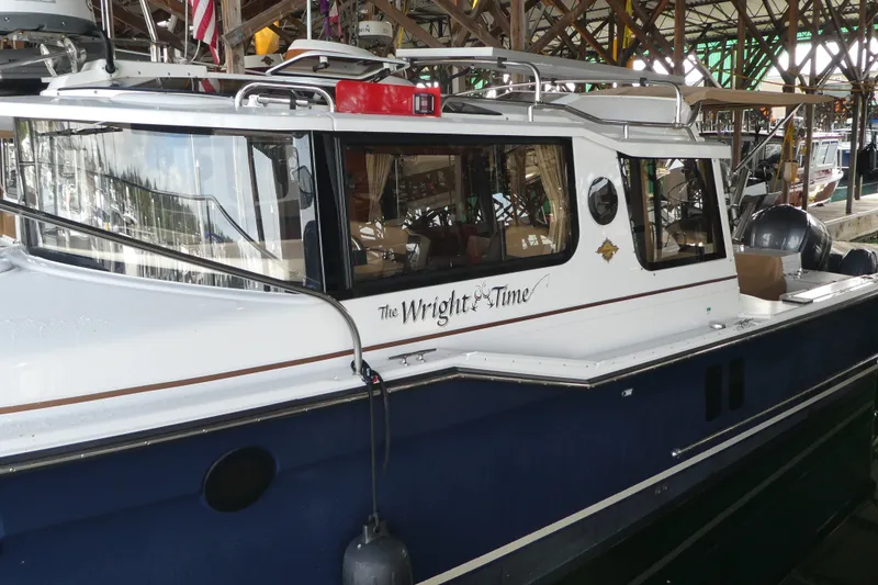 Slide: The Image of 2019 Ranger Tugs R-27 boat named "The Wright Time" docked in a marina. - 3