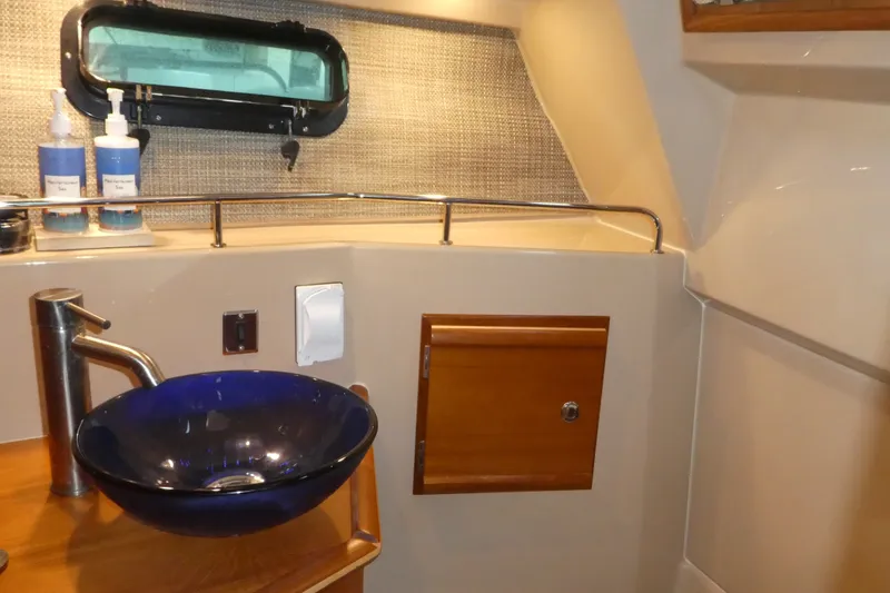 Slide: The Image of 2019 Ranger Tugs R-27 bathroom with blue glass sink and wooden cabinet. - 43