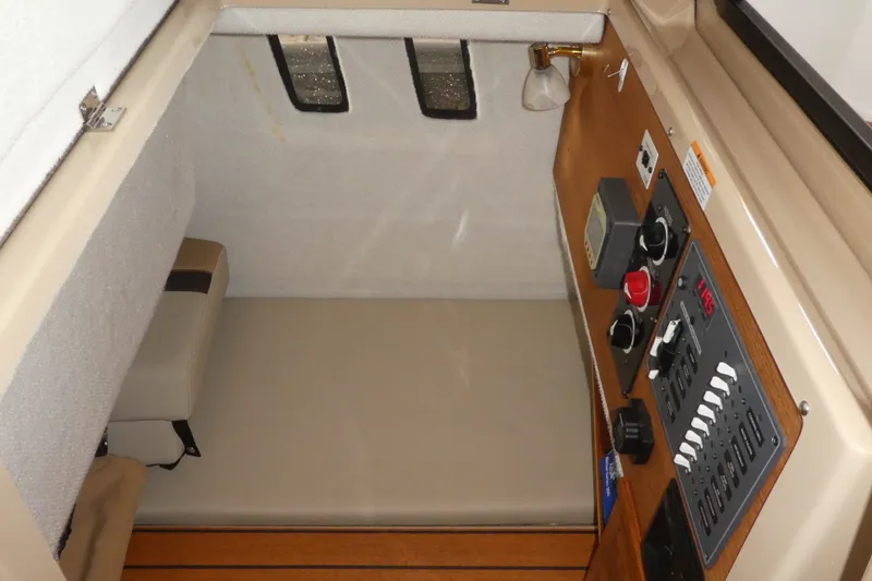 Slide: The Image of 2019 Ranger Tugs R-27 cabin interior with control panel and seating area. - 45