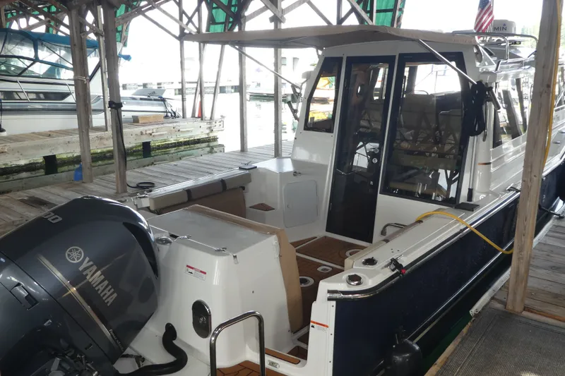 Slide: The Image of 2019 Ranger Tugs R-27 boat docked with Yamaha outboard motor in marina. - 1