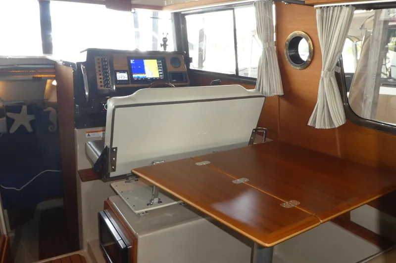 Slide: The Image of 2019 Ranger Tugs R-27 interior with navigation console and foldable wooden table. - 26