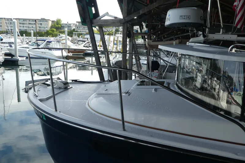 Slide: The Image of 2019 Ranger Tugs R-27 docked in a marina, surrounded by other boats. - 7
