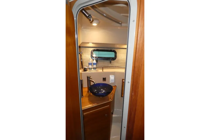 Slide: The Image of 2019 Ranger Tugs R-27 bathroom interior with modern sink and porthole window. - 41
