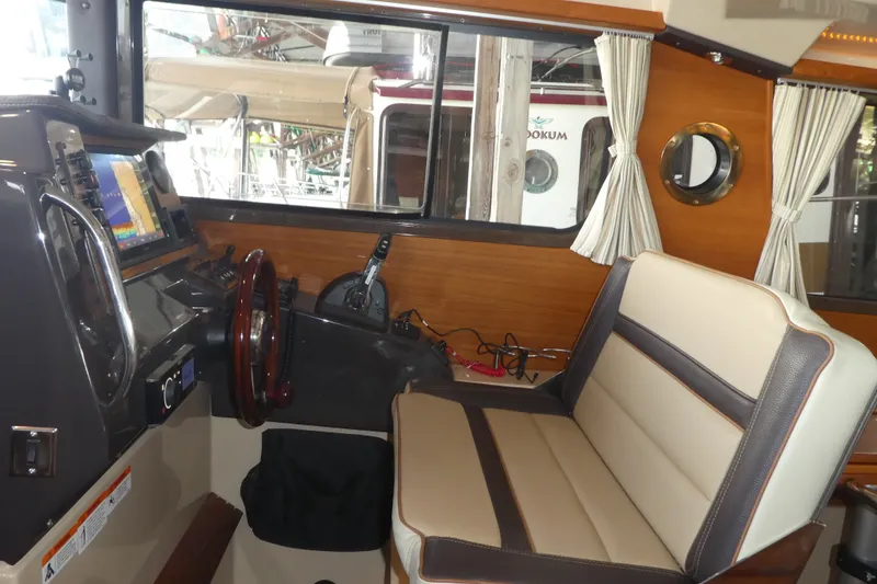 Slide: The Image of Interior of 2019 Ranger Tugs R-27 boat with navigation equipment and seating. - 25