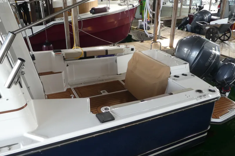 Slide: The Image of 2019 Ranger Tugs R-27 boat interior with Yamaha outboard motors in a marina setting. - 2