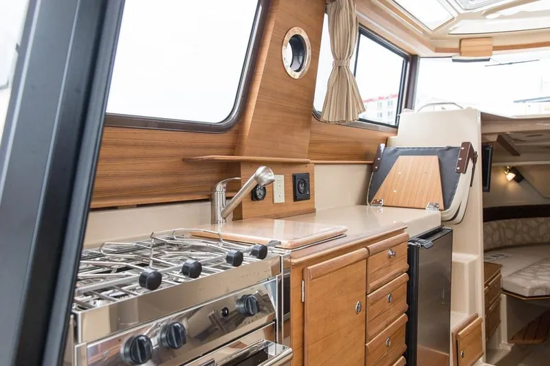 Slide: The Image of Manufacturer Provided Image: Interior of 2019 Ranger Tugs R-27 with kitchen and wooden cabinetry. - 18