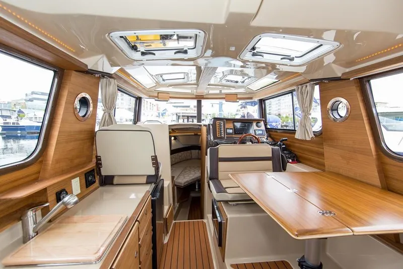 Slide: The Image of Manufacturer Provided Image: Interior of a 2019 Ranger Tugs R-27 boat with wood finishes and ample seating. - 15