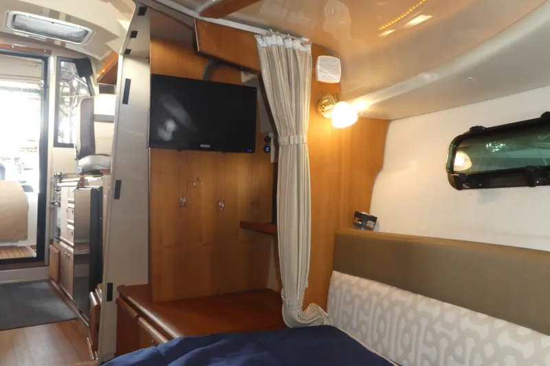 Slide: The Image of 2019 Ranger Tugs R-27 interior cabin with TV, bed, and window. - 40