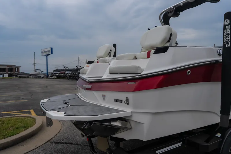 Slide: The Image of 2023 MasterCraft XT24 boat with sleek design and comfortable seating in a parking lot. - 39