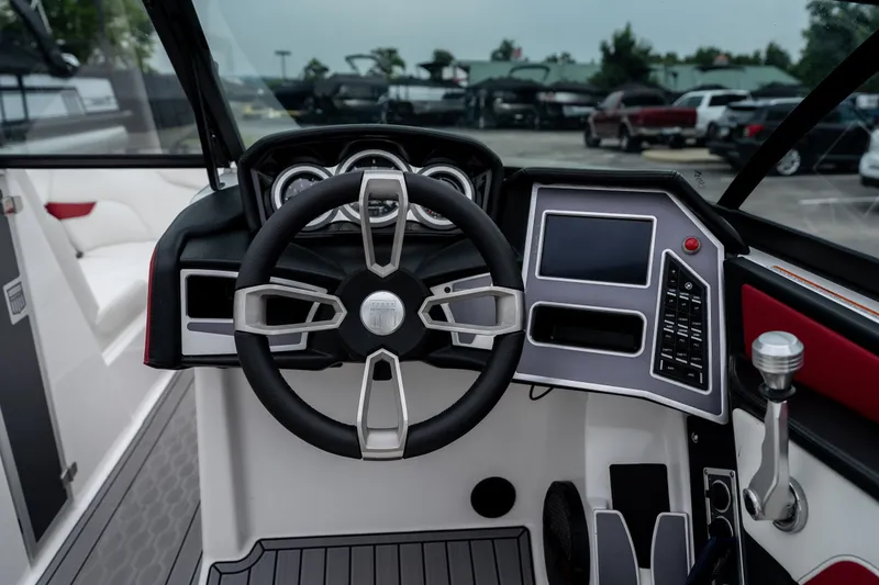 Slide: The Image of 2023 MasterCraft XT24 boat dashboard with steering wheel and control panel. - 16
