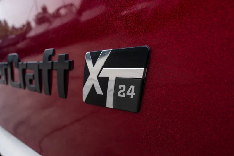 Slide: The Image of Close-up of 2023 MasterCraft XT24 logo on a red surface. - 50