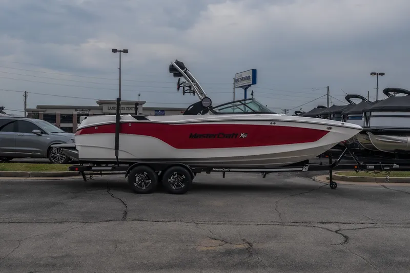 Slide: The Image of 2023 MasterCraft XT24 boat on trailer in parking lot, overcast sky. - 51