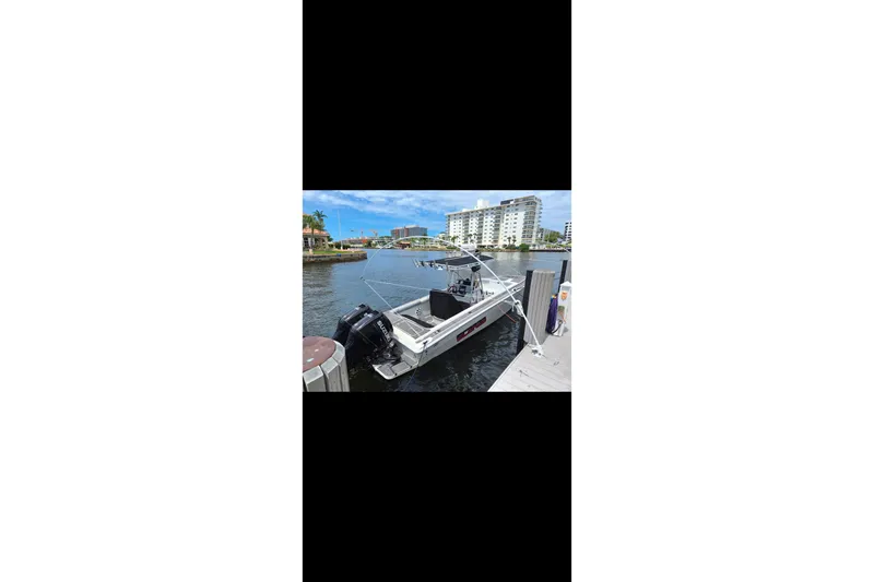 Slide: The Image of 1997 Wellcraft 30 Scarab Sport boat docked by waterfront buildings. - 26