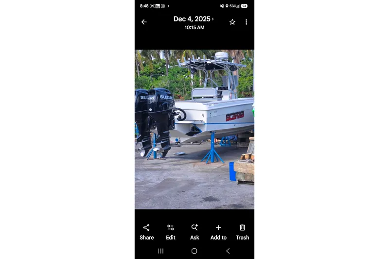 Slide: The Image of 1997 Wellcraft 30 Scarab Sport boat on stands, dual Suzuki outboard motors visible. - 18