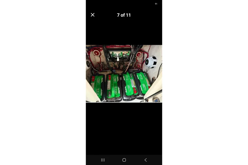 Slide: The Image of Battery compartment of a 1997 Wellcraft 30 Scarab Sport boat with multiple green batteries. - 13