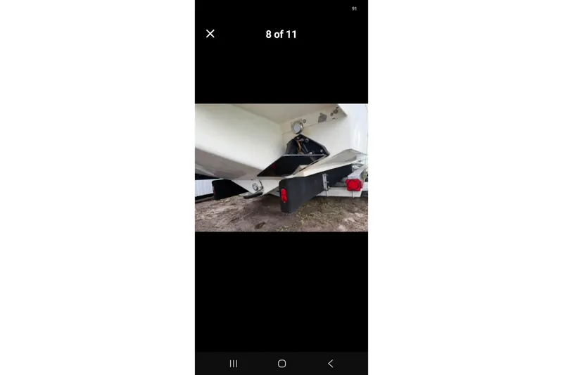Slide: The Image of 1997 Wellcraft 30 Scarab Sport boat trailer view with visible propeller and rudder. - 16