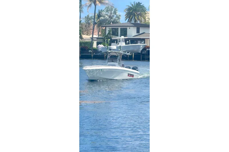 The Image of 1997 Wellcraft 30 Scarab Sport boat cruising on a sunny waterway. - 1