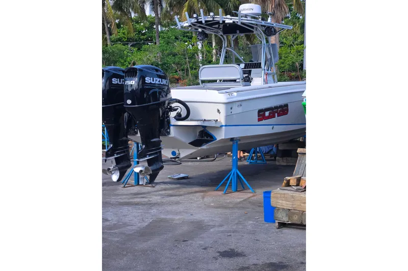 Slide: The Image of 1997 Wellcraft 30 Scarab Sport boat with twin Suzuki outboard motors on stands. - 23