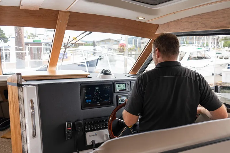 Slide: The Image of Interior view of a 2027 Cutwater C-32 CB boat with a person at the helm. - 16