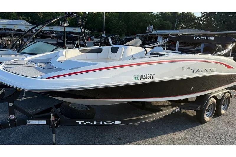 The Image of 2023 Tahoe 2150 boat on trailer, white and black design, parked outdoors. - 0