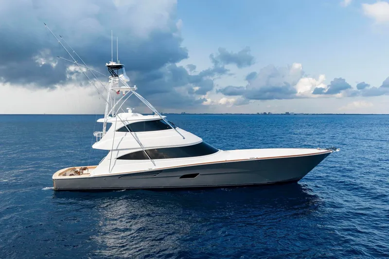 The Image of 2026 Viking 82 Enclosed Bridge yacht cruising on open sea under cloudy sky. - 0