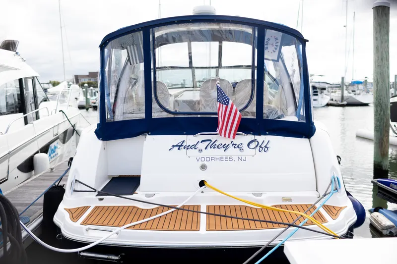 Slide: The Image of 2005 Sea Ray 340 Sundancer docked, featuring "And They're Off" signage and American flag. - 5