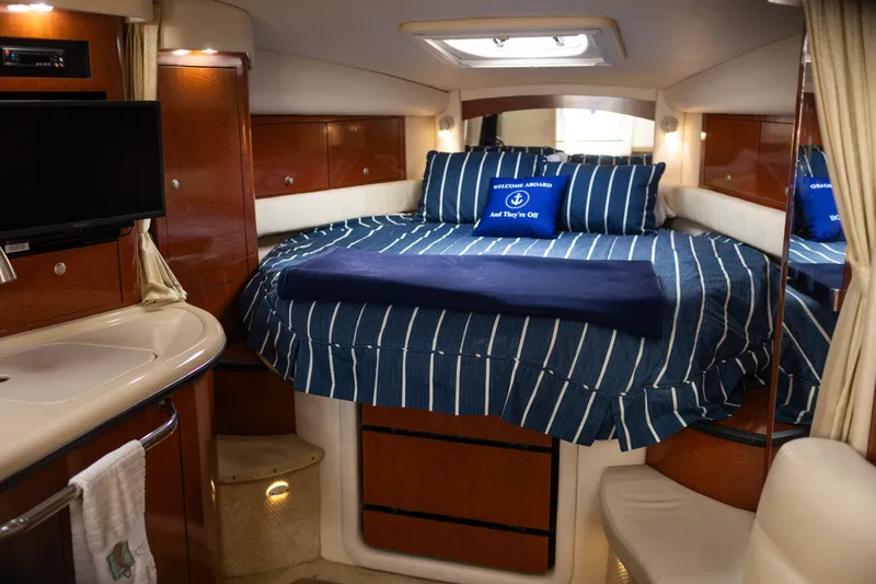 Slide: The Image of Interior cabin of 2005 Sea Ray 340 Sundancer with striped bedding and cozy amenities. - 24