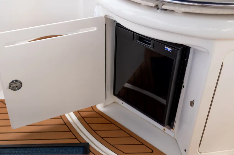 Slide: The Image of 2005 Sea Ray 340 Sundancer interior with open cabinet and mini fridge. - 13