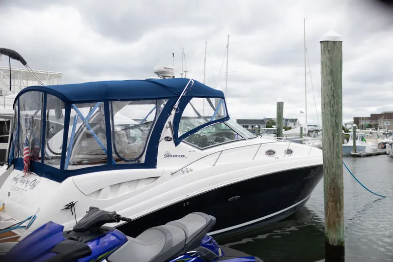 The Image of 2005 Sea Ray 340 Sundancer yacht docked at marina under cloudy skies. - 0