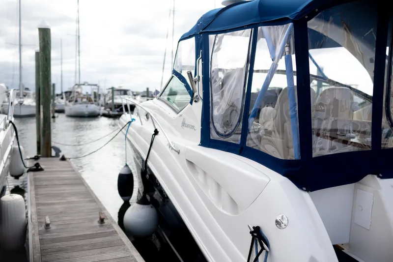 Slide: The Image of 2005 Sea Ray 340 Sundancer docked at marina, featuring blue canopy and sleek design. - 27