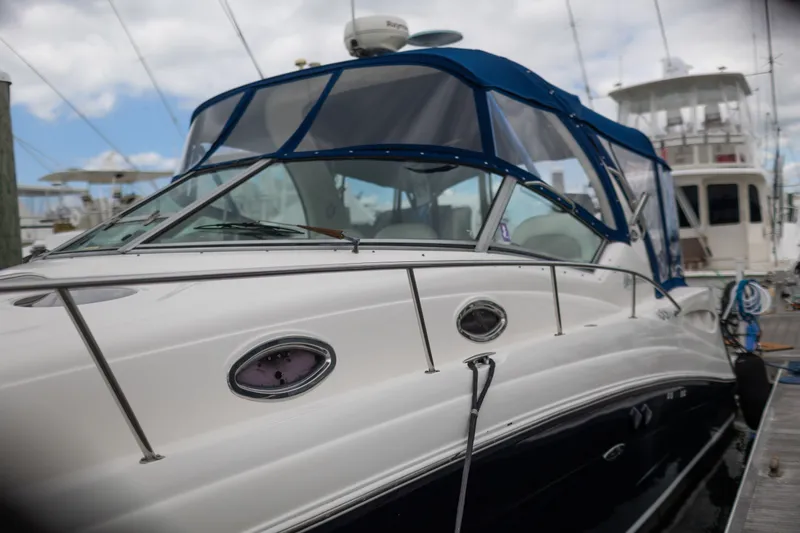 Slide: The Image of 2005 Sea Ray 340 Sundancer yacht docked, featuring sleek design and blue canopy. - 25