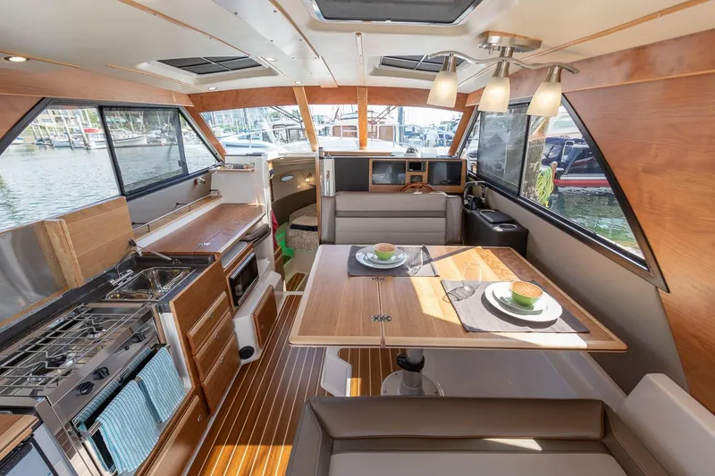 Slide: The Image of Interior of 2027 Cutwater C-32 CB boat featuring modern kitchen and dining area. - 17