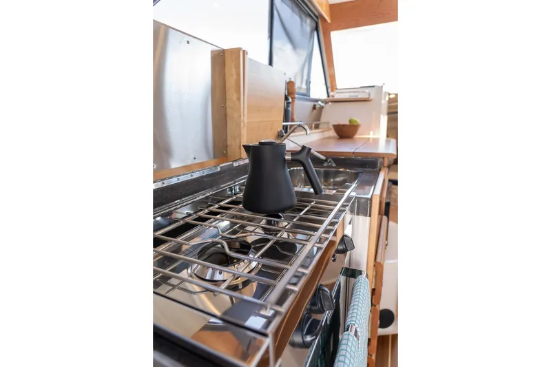Slide: The Image of Modern kitchen interior of 2027 Cutwater C-32 CB boat with stove and kettle. - 22