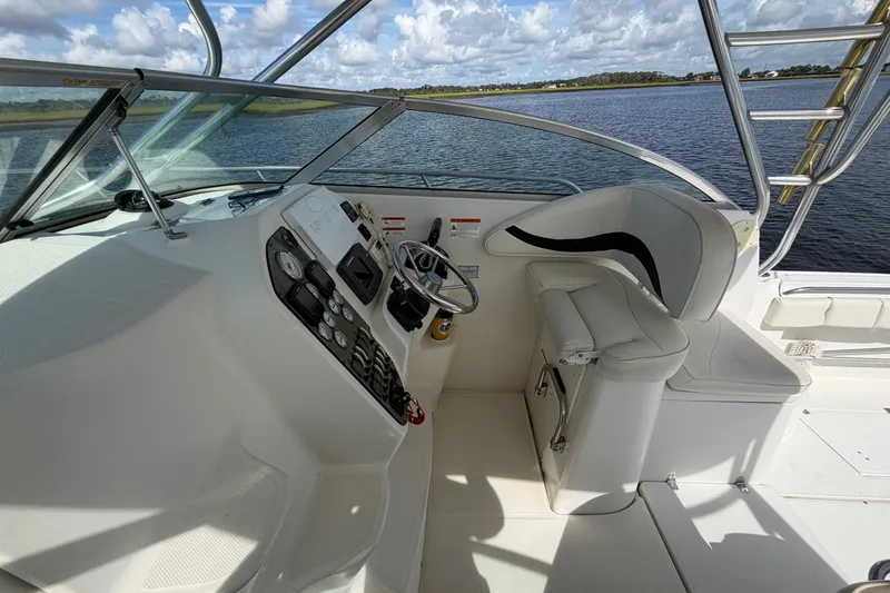 Slide: The Image of 2004 Seaswirl Striper 2901 Walkaround O/B helm with steering wheel and controls, overlooking water. - 25