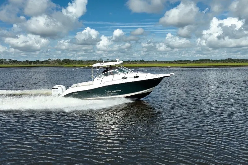 Slide: The Image of 2004 Seaswirl Striper 2901 Walkaround O/B cruising on a scenic waterway under a cloudy sky. - 36