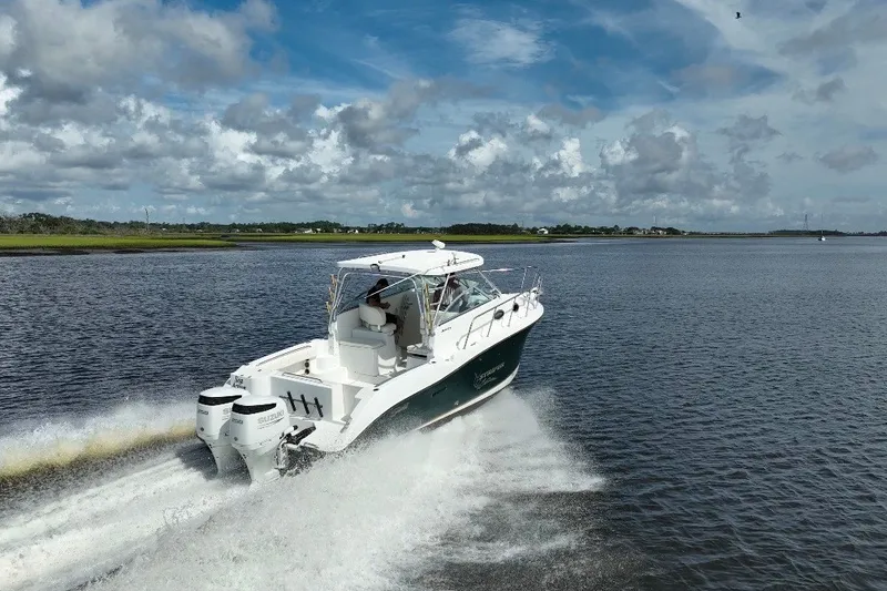 Slide: The Image of 2004 Seaswirl Striper 2901 Walkaround O/B cruising on open water under a cloudy sky. - 35