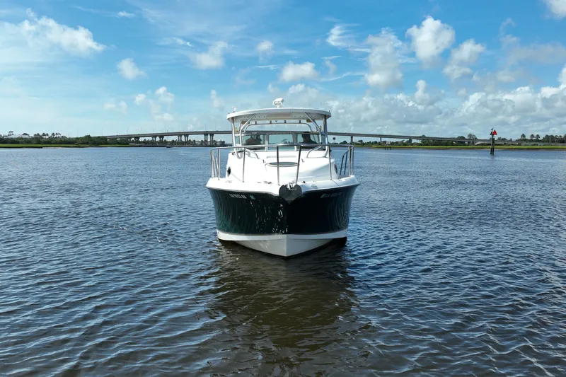 The Image of 2004 Seaswirl Striper 2901 Walkaround O/B boat on calm water under blue sky. - 1