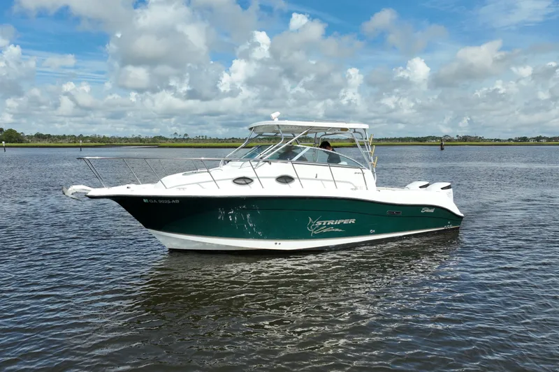 Slide: The Image of 2004 Seaswirl Striper 2901 Walkaround O/B boat on calm water under cloudy sky. - 14