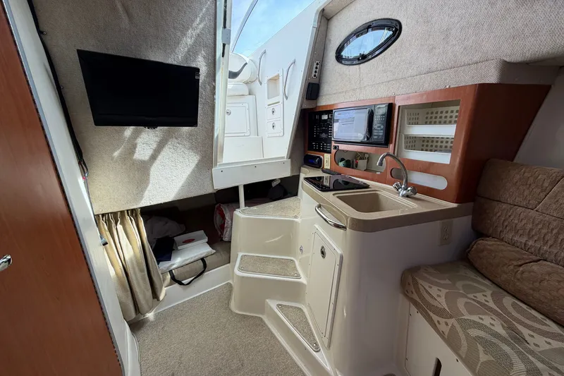 Slide: The Image of 2004 Seaswirl Striper 2901 Walkaround O/B cabin interior with kitchenette and seating area. - 32